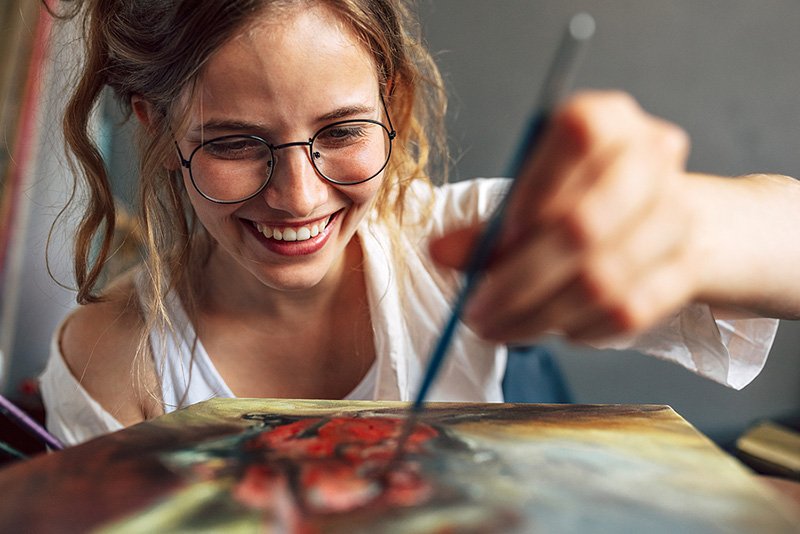 Closeup Of A Pretty Female Artist Painting With A Brush On Canva
