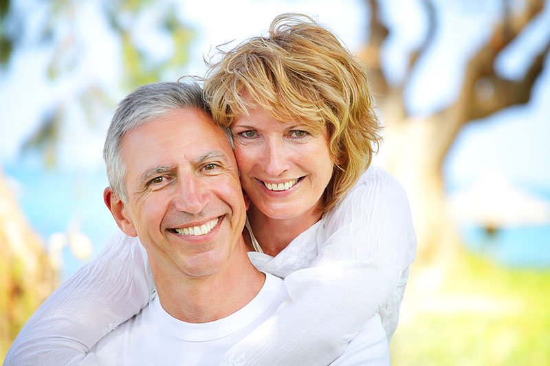 older couple smiling with dental crowns