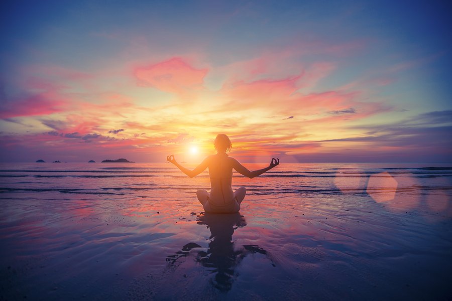 Woman meditating on the beach